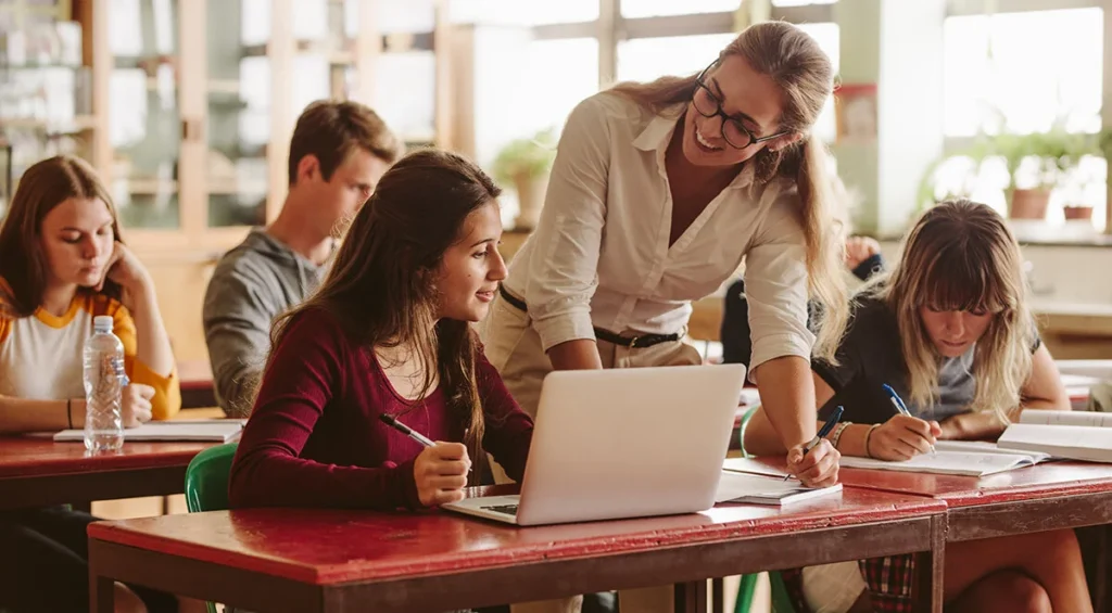 Teacher working with high school students, the staff a school security plan depends on