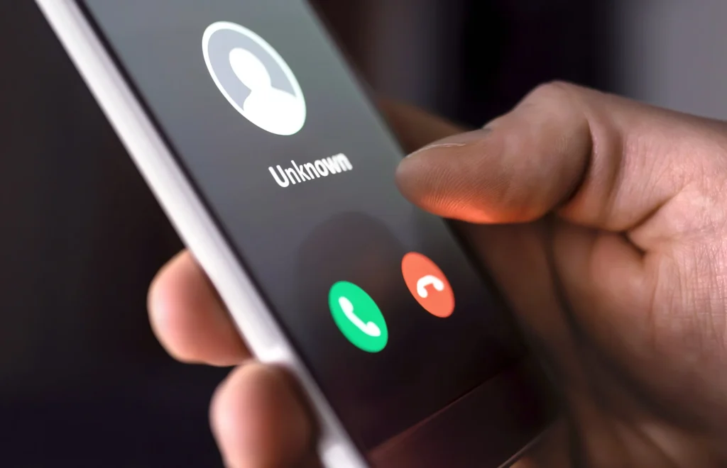 Smartphone showing an incoming call from an unknown number, typical of robocall scams